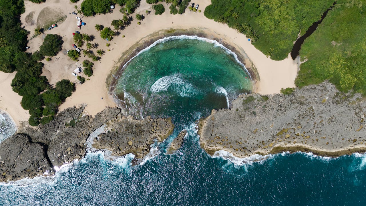 Stunning aerial view of Playa Mar Chiquita's turquoise waters and rocky coastline in Puerto Rico.